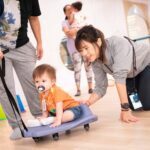 LOving teacher and toddler boy sliding at Aocrn Playhouse